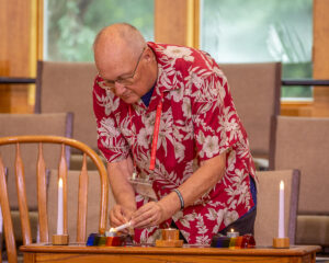 Don Peterson lights the candles for Joys and Sorrows.